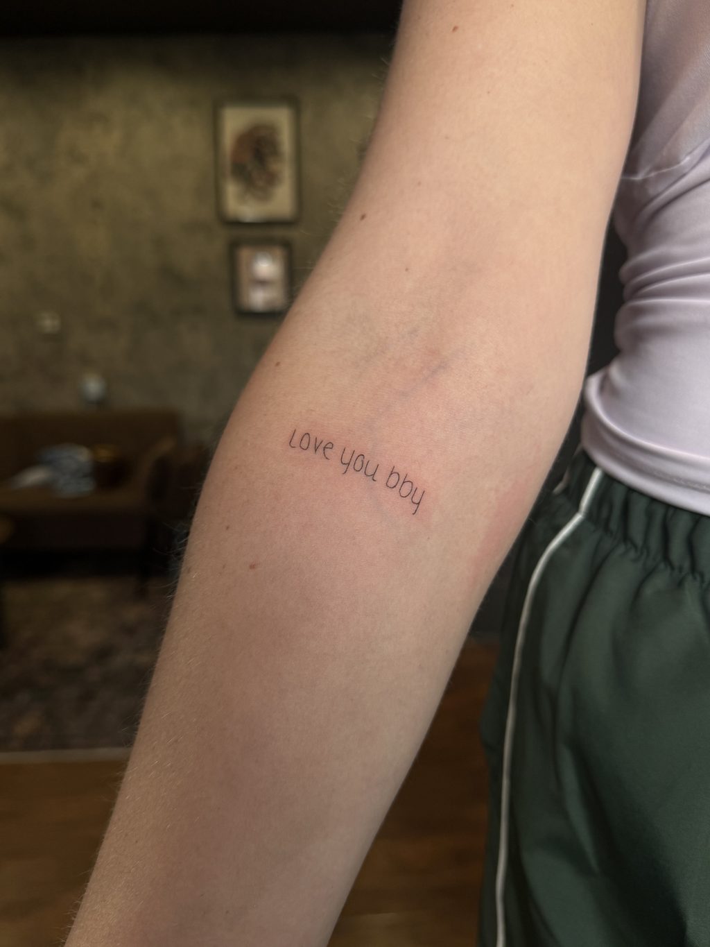 Delicate fine-line script tattoo on the inner arm.