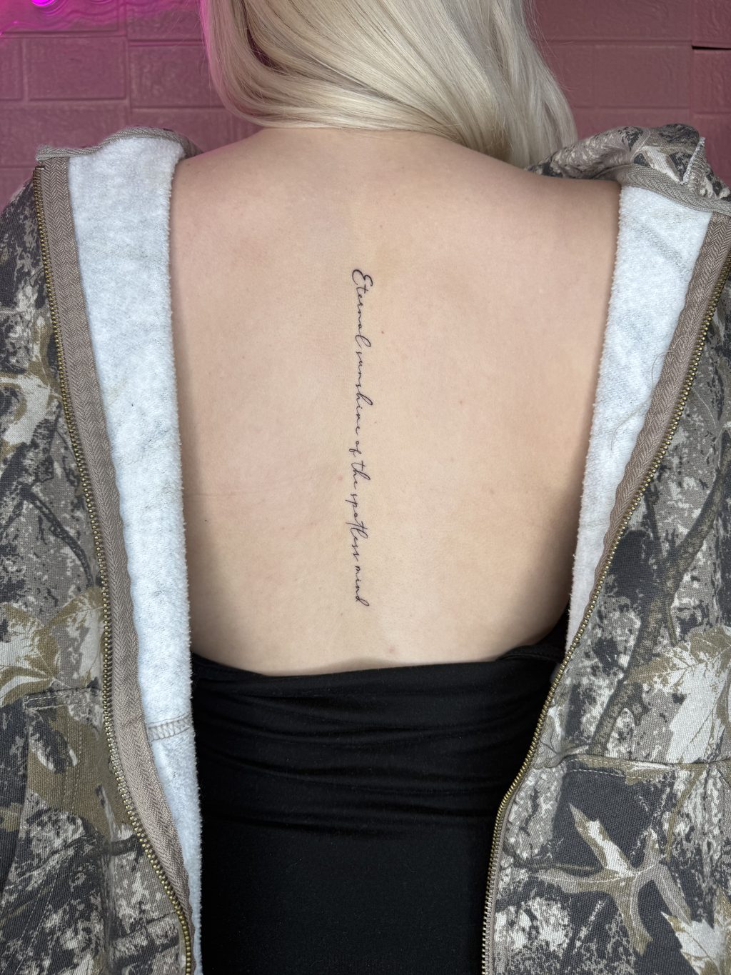 Fine-line script lettering tattoo.