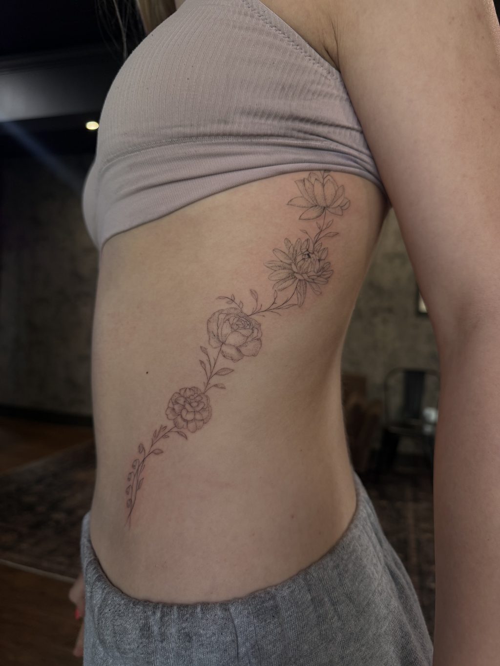 Fine-line floral branch of lilies and peonies along the ribs.