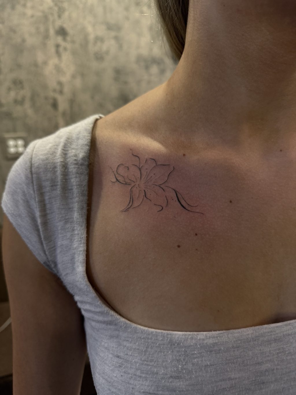 Single fine-line lily tattoo.
